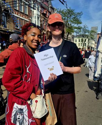 Twee lezers met het boek in hun handen, op straat op Koningsdag