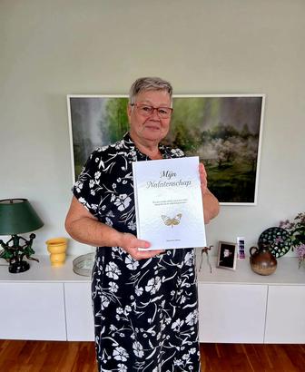 De moeder van Leandra met het boek, thuis in haar woonkamer